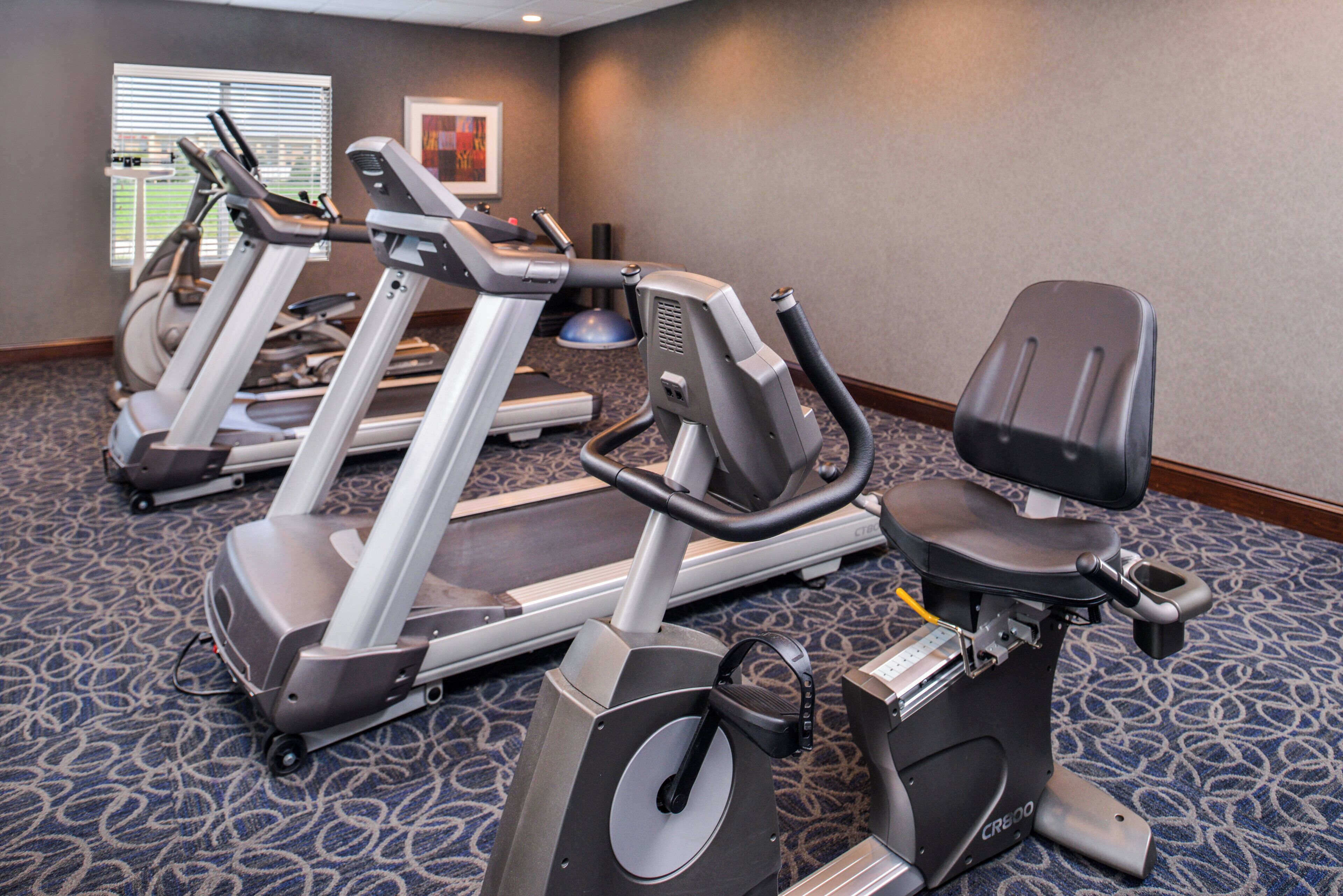 A hotel fitness center with treadmills and an elliptical machine.