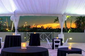 Guests can dine under a shaded canopy with a view of the surrounding cityscape and palm trees.