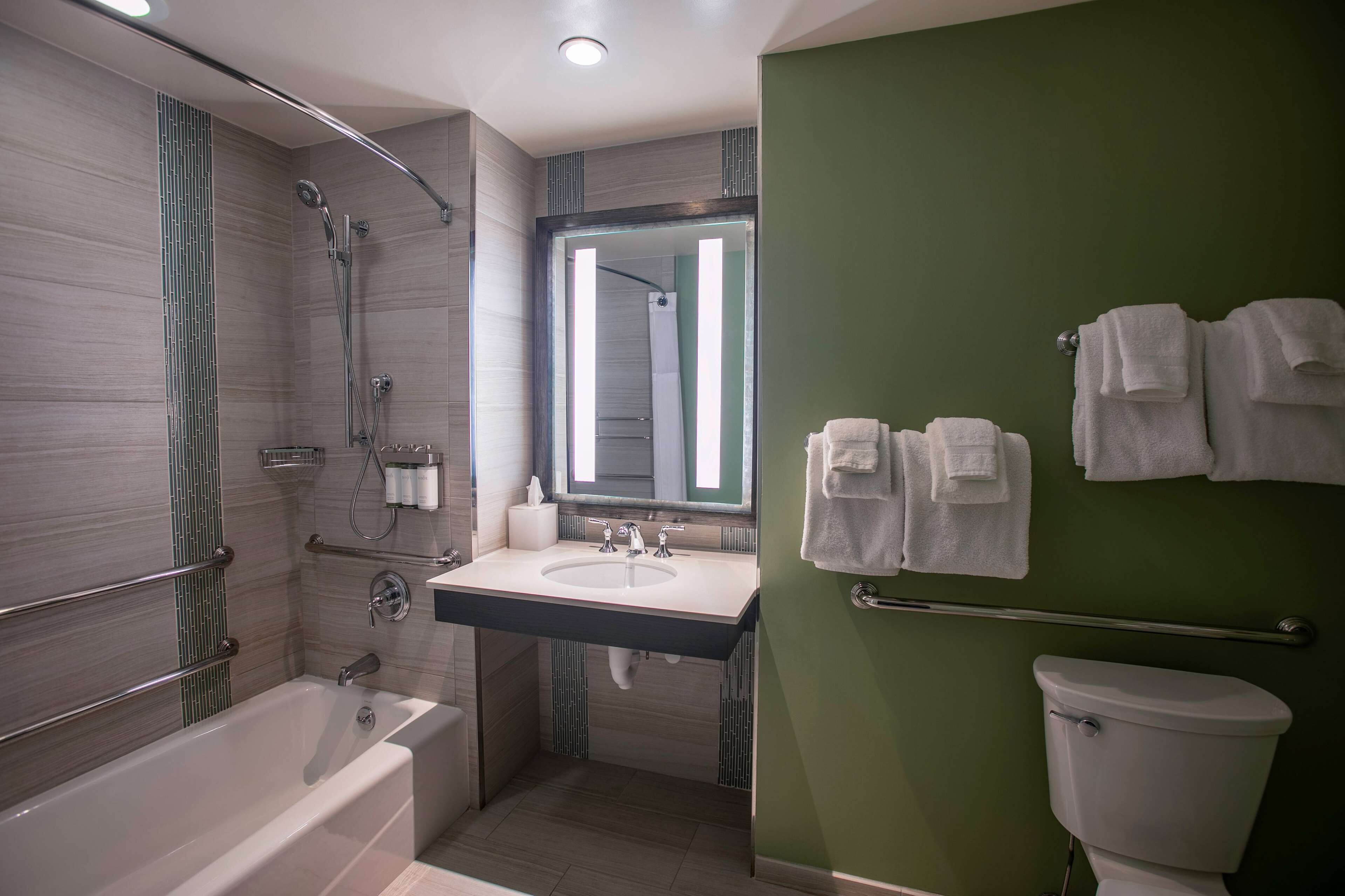 Un baño moderno con bañera, lavamanos e inodoro.