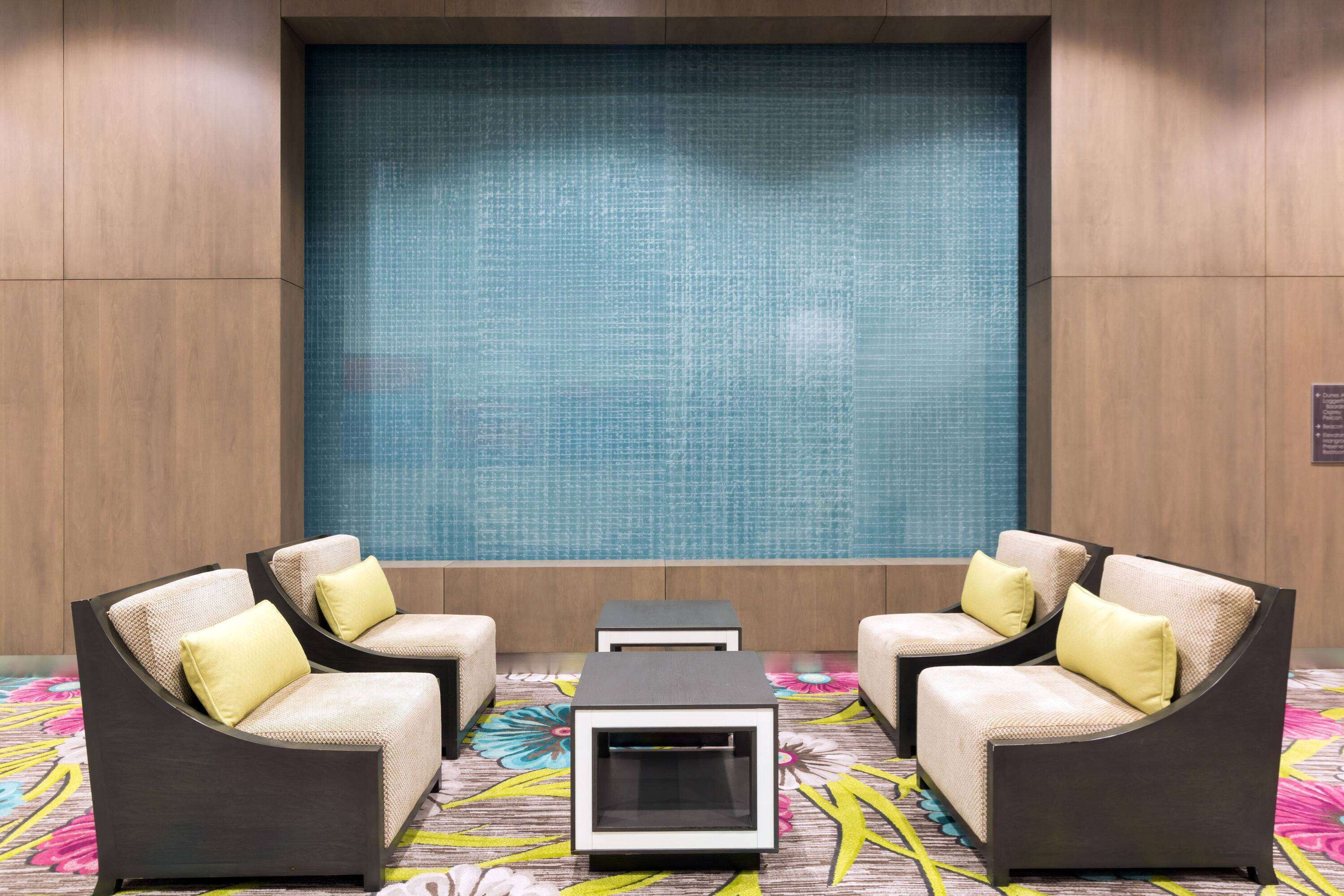 A seating area with two sofas and a coffee table, a decorative wall, and a patterned carpet.