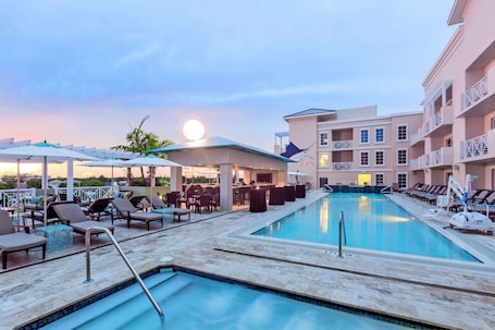 Una piscina al aire libre, sillones reclinables de piscina