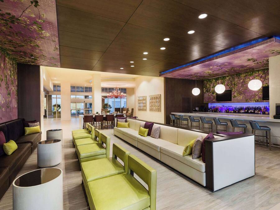 Un área de lounge moderna con asientos, un bar y una pared decorativa.