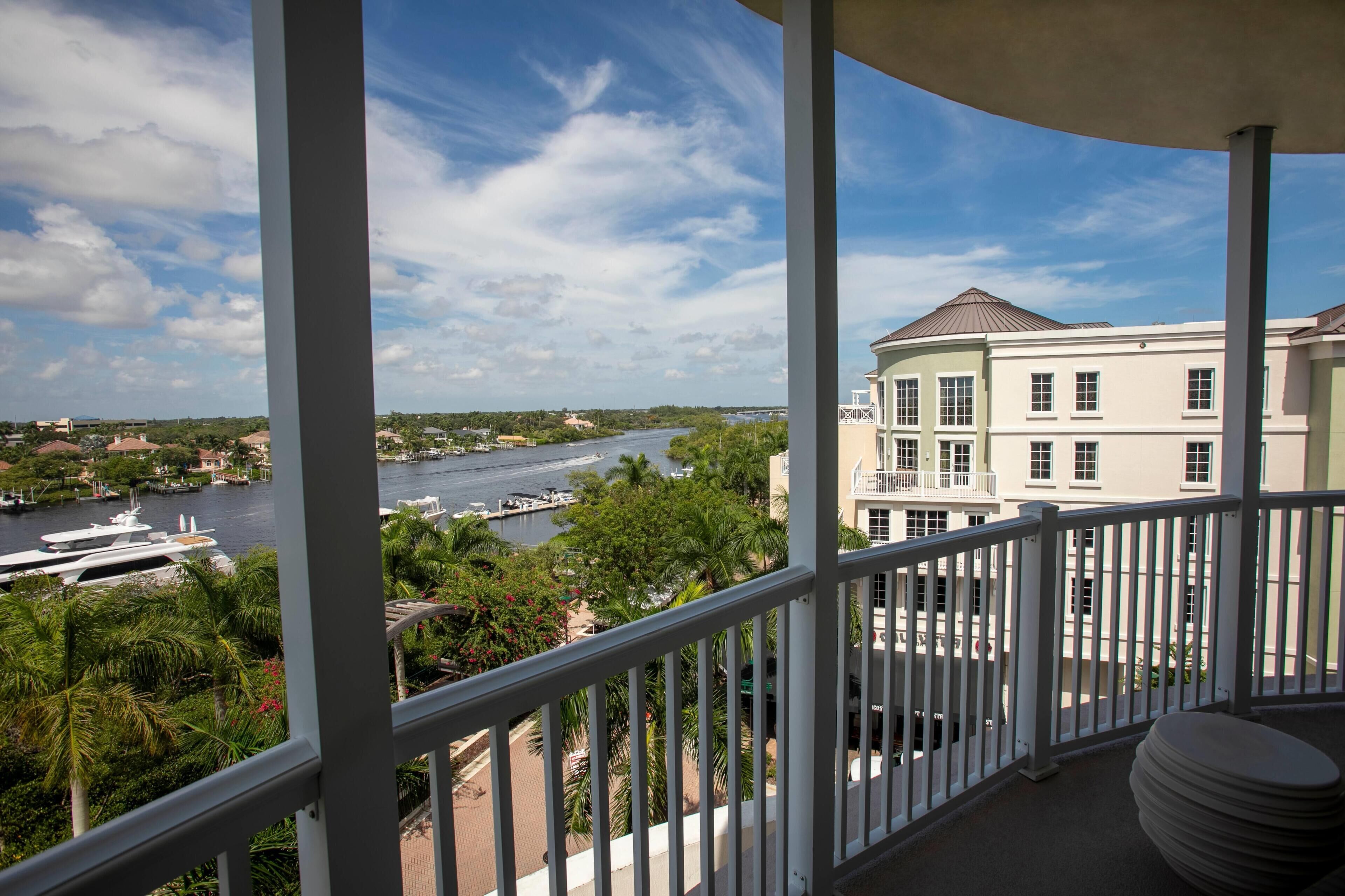 A balcony with a view of a river, boats, and buildings.