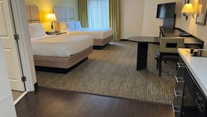 A hotel room with two beds, a desk, a TV, and a small kitchenette. - Candlewood Suites Eugene Springfield by IHG (Eugene)
