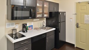 A compact kitchen with a microwave, refrigerator, sink, and dishwasher. - Candlewood Suites Eugene Springfield by IHG (Eugene)