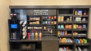 A self-service kiosk with a coffee machine, a microwave, and a variety of snacks and beverages. - Candlewood Suites Eugene Springfield by IHG (Eugene)