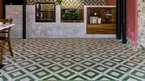 Een café interieur met een patroon vloer, een toonbank met planken, en een bord met de tekst 'CAFEERIA CASA ZARAGOZA HISTORIASABORES'.