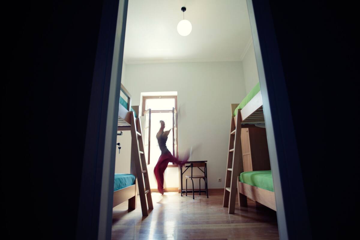 Une chambre avec des lits superposés, un bureau et une chaise.