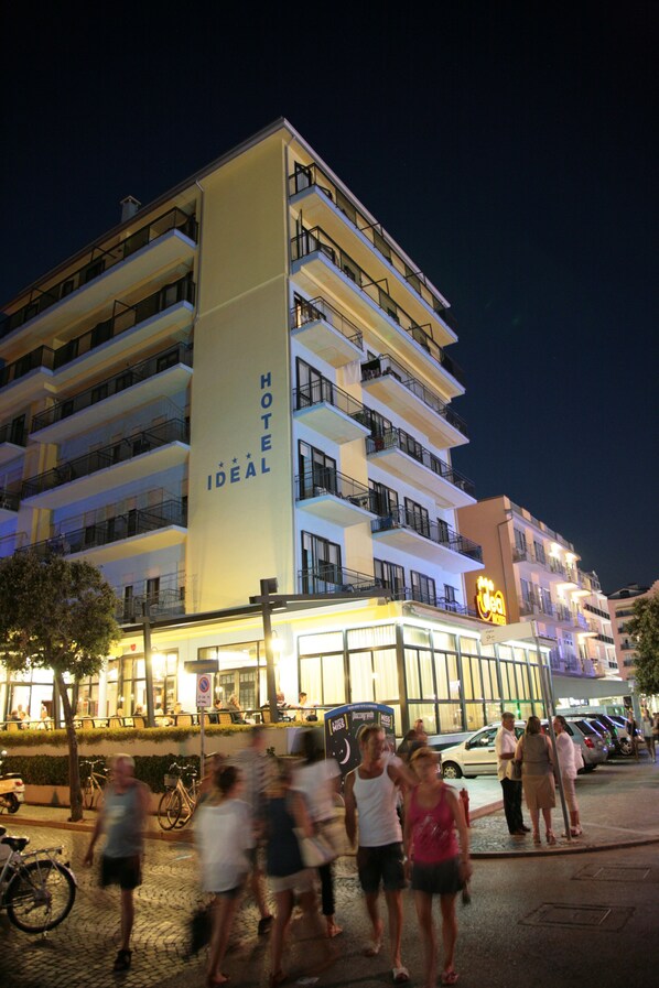 A multi-story hotel with balconies and a sign reading "HOTEL IDEAL".
