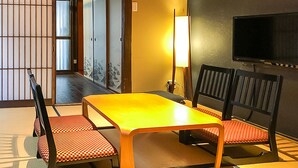 A traditional Japanese room with tatami flooring, a low table, and two chairs with red cushions. - Kyoto Miyabi Inn -Only one group a day- (Kyoto)