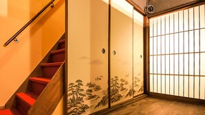 A staircase with red steps leading to a room with sliding doors featuring a traditional landscape painting. - Kyoto Miyabi Inn -Only one group a day- (Kyoto)