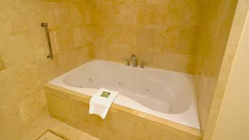 Une salle de bain moderne avec une grande baignoire, une barre d’appui et un porte-serviettes.