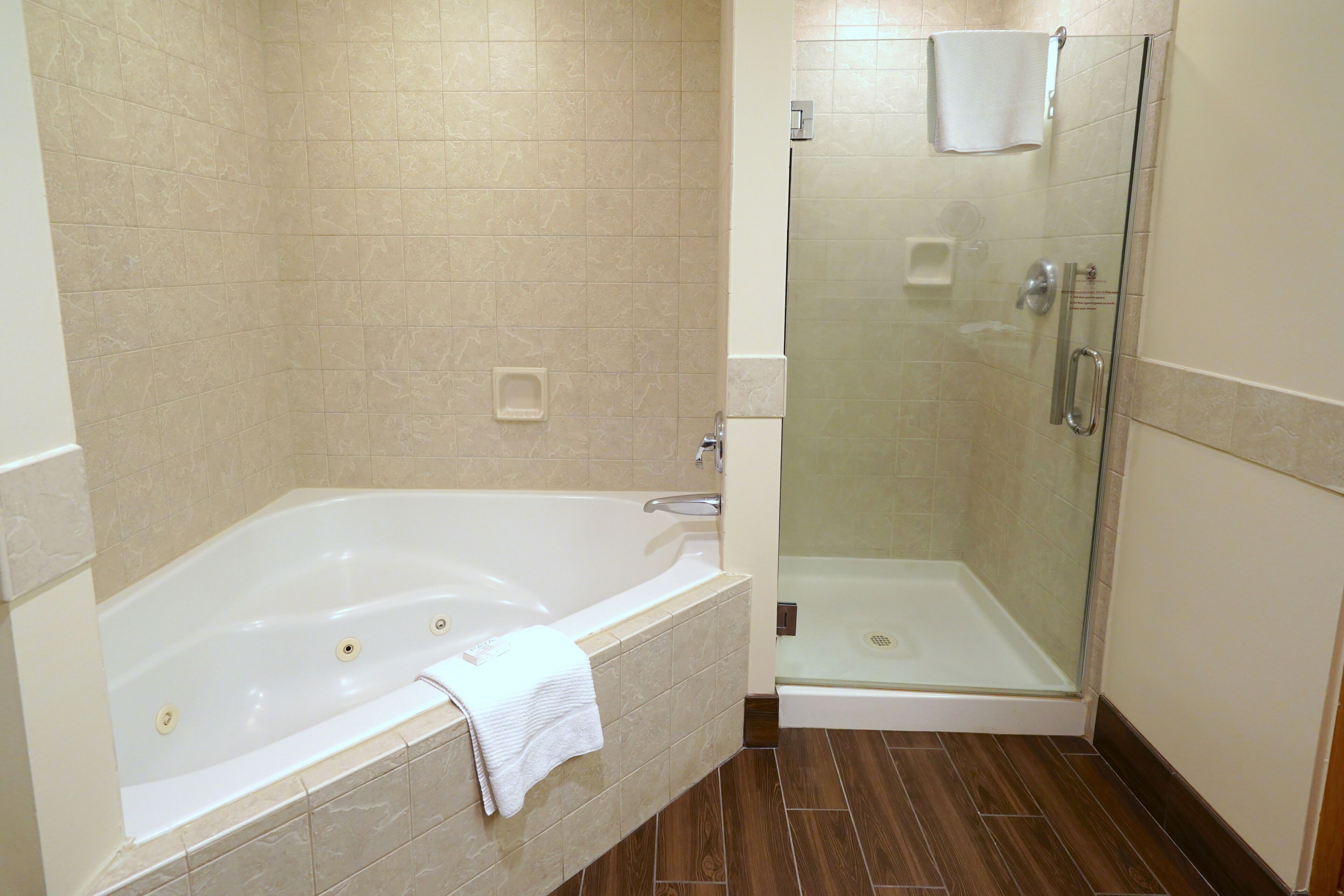 A bathroom with a bathtub, a glass-enclosed shower, and a toilet.