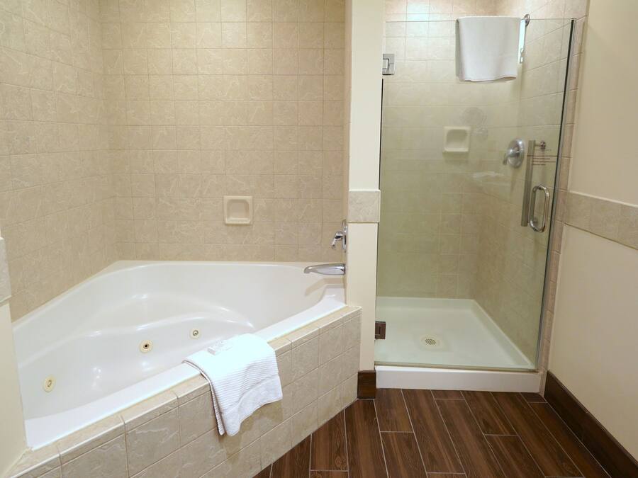 A bathroom with a bathtub, a glass-enclosed shower, and a toilet.