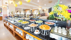 A buffet with various food items and a decorative centerpiece. - Beachfront Hotel (Ho Chi Minh City)