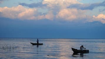 Una masa de agua tranquila con dos barcos y una persona en cada uno, bajo un cielo parcialmente nublado.