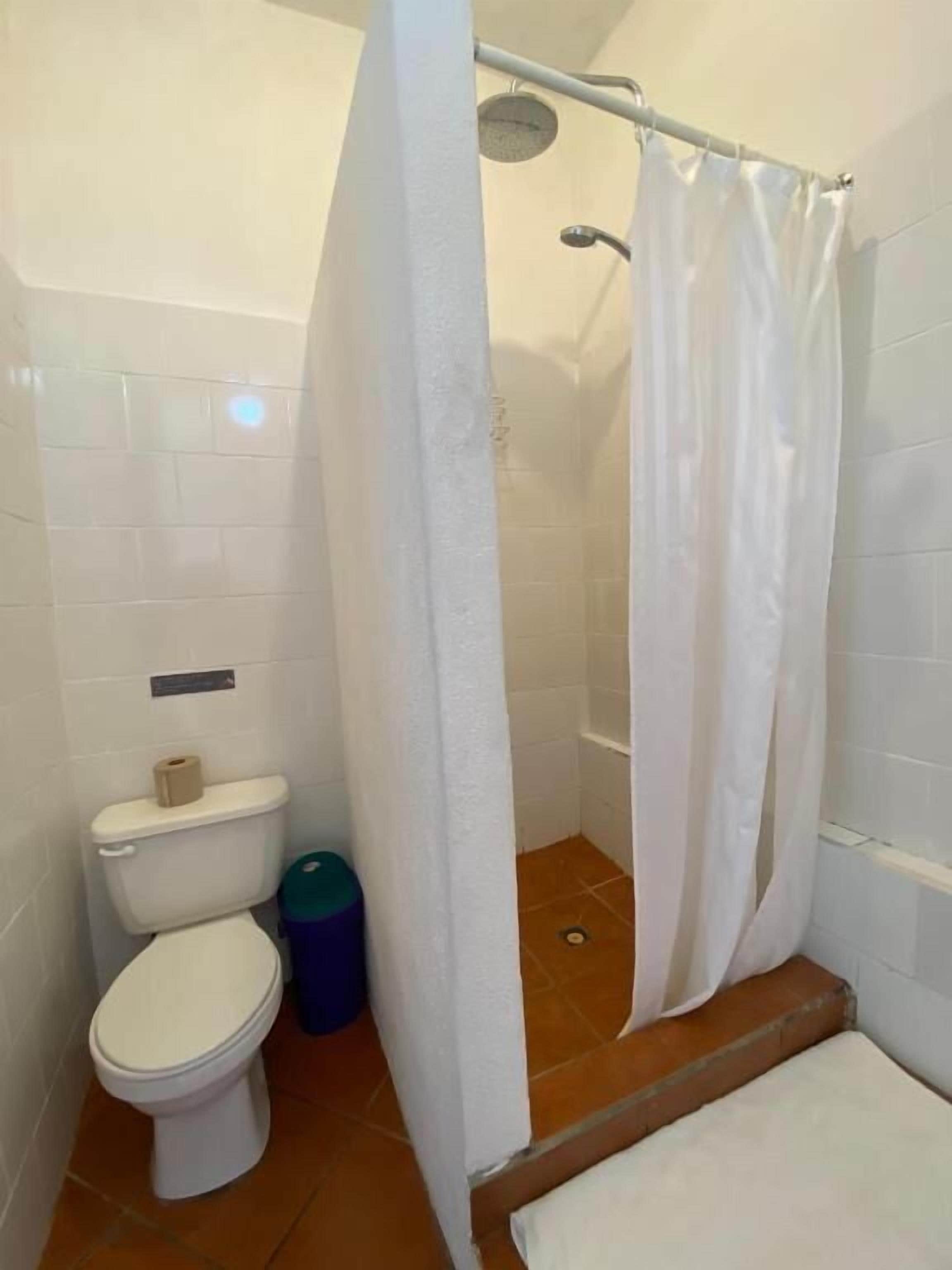 Un baño pequeño con inodoro, ducha y un perchero para toallas.