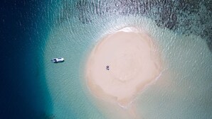 An aerial view of a beach with a boat and a person on the sand. - Emaho Sekawa Resort (Savusavu)