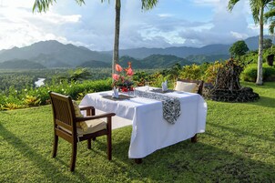 Mesa al aire libre con vista a montañas y un río.