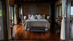 A wooden-framed bedroom with a bed, pillows, and a bench. - Emaho Sekawa Resort (Savusavu)