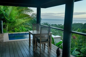 A wooden deck with a pool, a chair, and a view of the ocean. - Emaho Sekawa Resort (Savusavu)