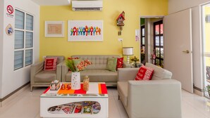 Un salon avec deux canapés, une table basse et un climatiseur fixé au mur.