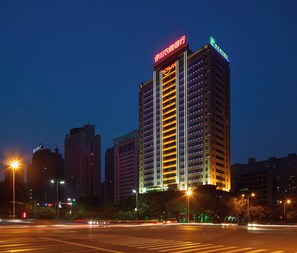 A high-rise building with illuminated signage, multiple floors, and a modern architectural design. - Holiday Inn Express Luoyang City Center by IHG (Luoyang)