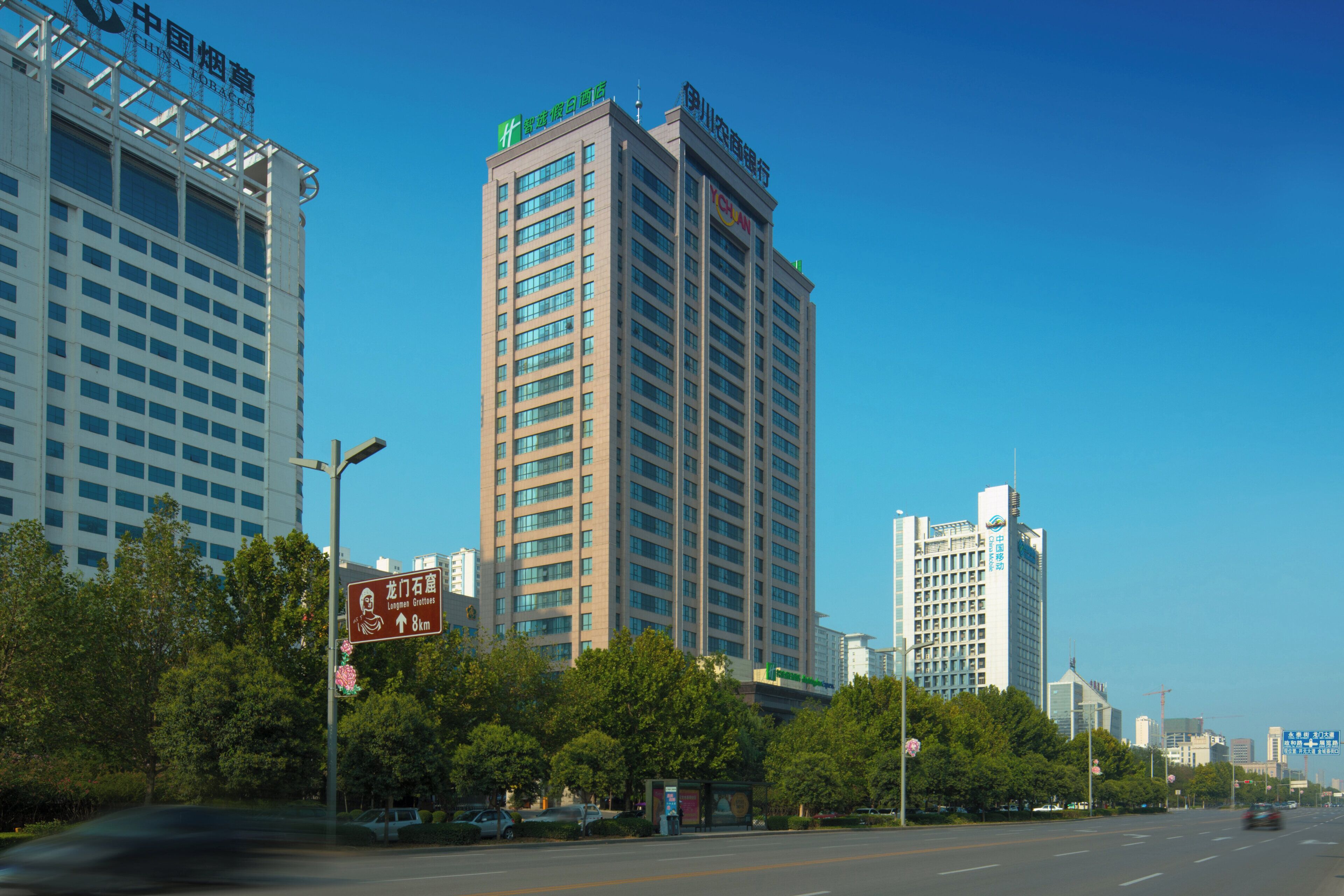 A multi-story hotel with a modern design, featuring a prominent sign at the top.