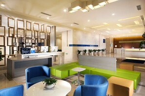 A modern reception area with a counter, seating, and a plant. - Holiday Inn Express Luoyang City Center by IHG (Luoyang)