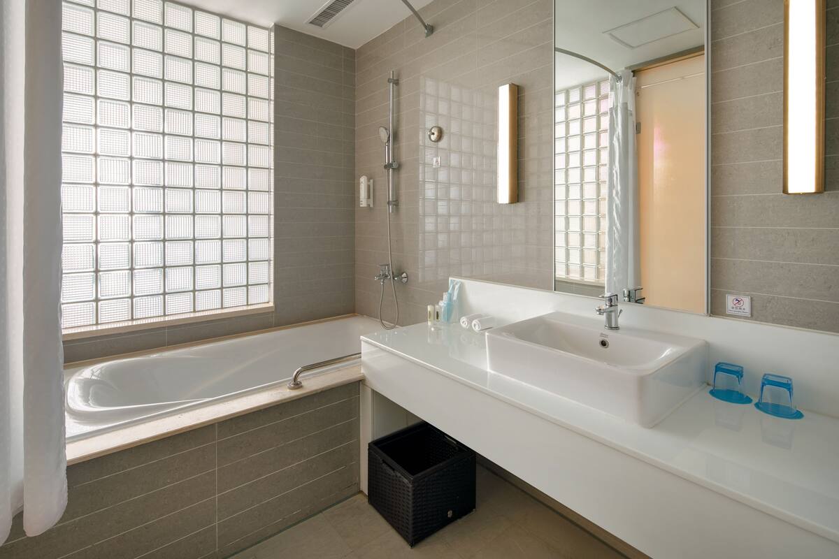 deep-soaking bathtub, rainfall showerhead, hair dryer, slippers