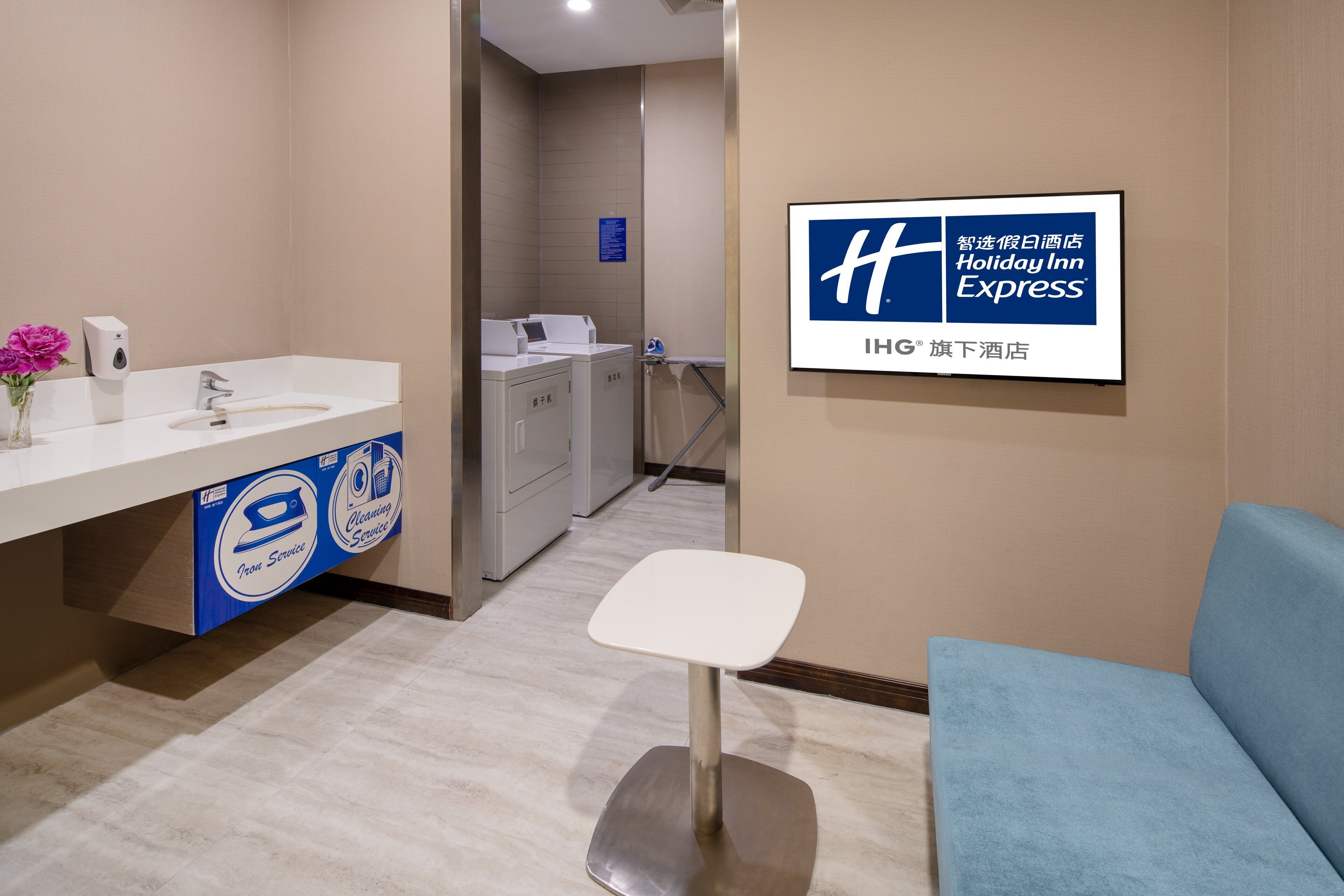 A hotel lobby with a reception desk, a seating area, and a visible laundry service sign.