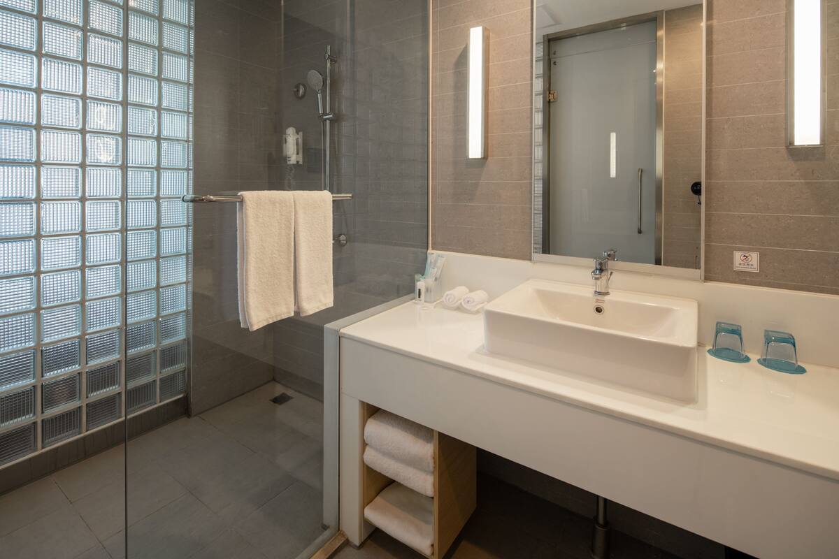 deep-soaking bathtub, rainfall showerhead, hair dryer, slippers