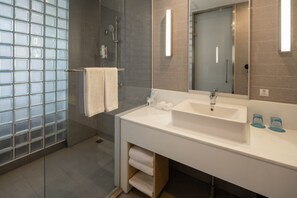 A modern bathroom with a large mirror, two sinks, and a glass shower enclosure. - Holiday Inn Express Luoyang City Center by IHG (Luoyang)