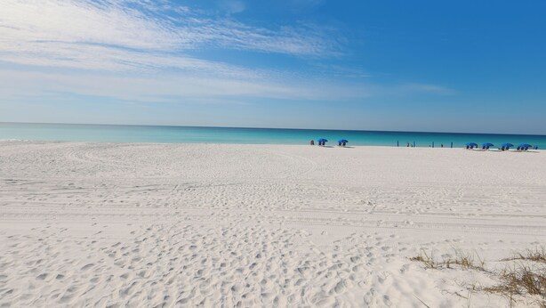 Una playa con huellas y un cielo despejado.