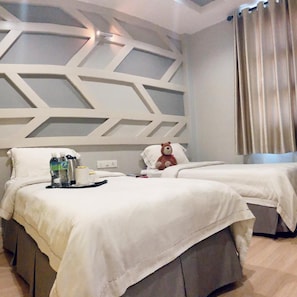 A hotel room with two beds, a decorative wall, and a curtain. - Sunshine Inn Malacca (Malacca City)