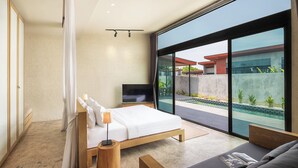 A modern bedroom with a large window, a bed, a TV, and a seating area.