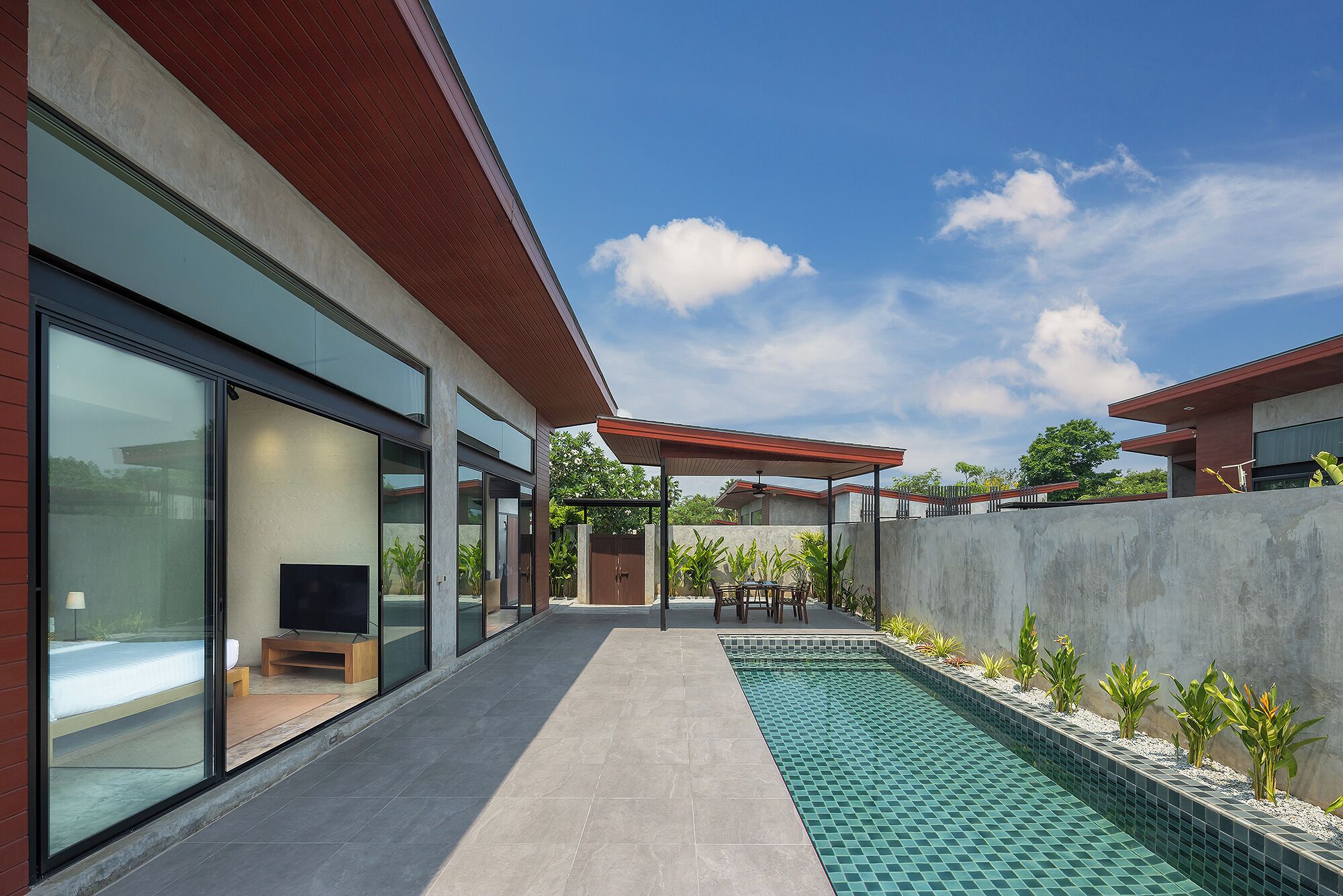 Una casa moderna con fachada de vidrio, piscina y zona de patio.