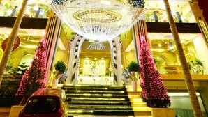 A hotel with a grand entrance, a staircase leading to the lobby, and palm trees. - Holiday One Hotel (Can Tho)