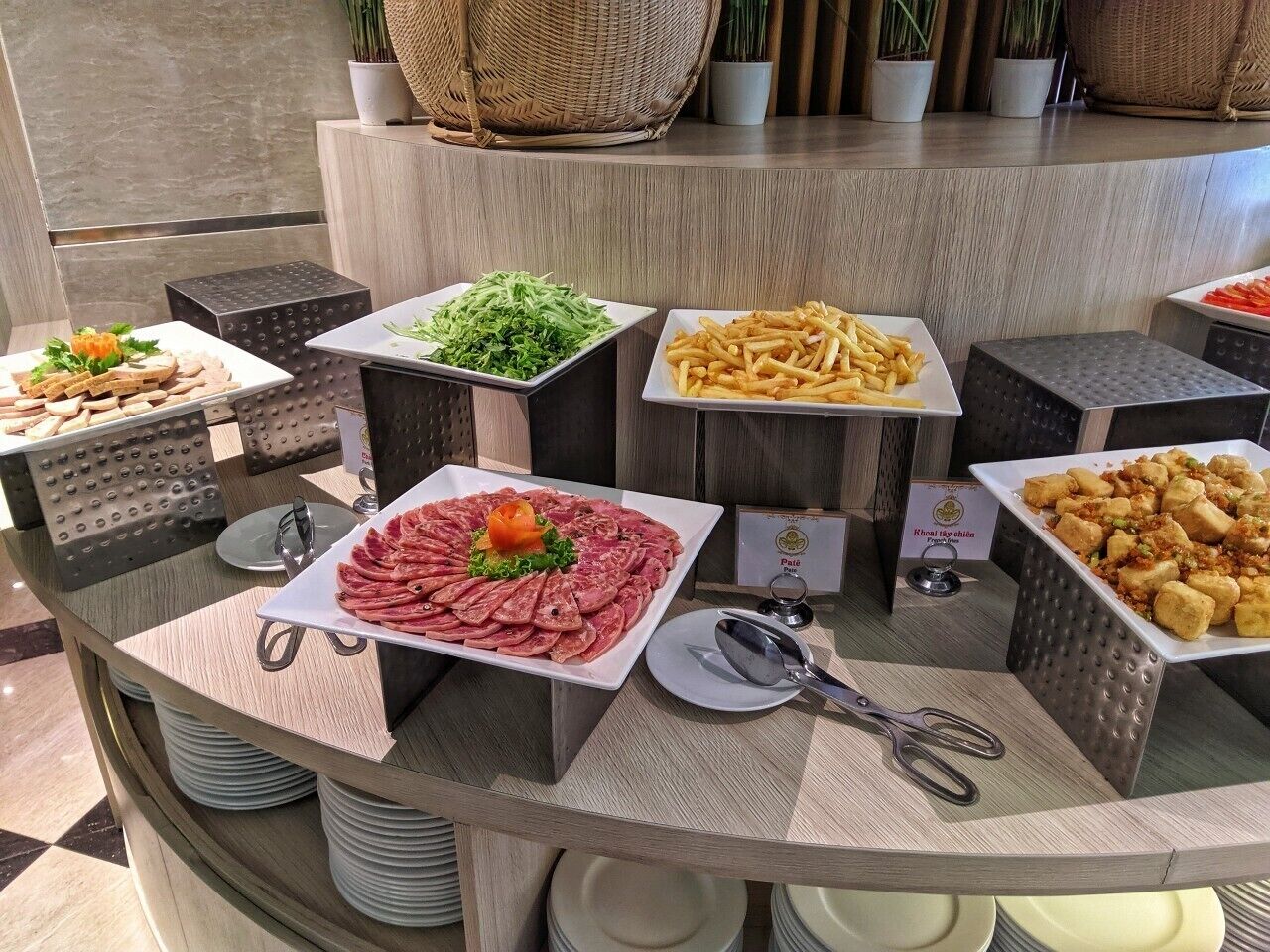 A buffet with various food items including sliced meats, salads, and fried foods.