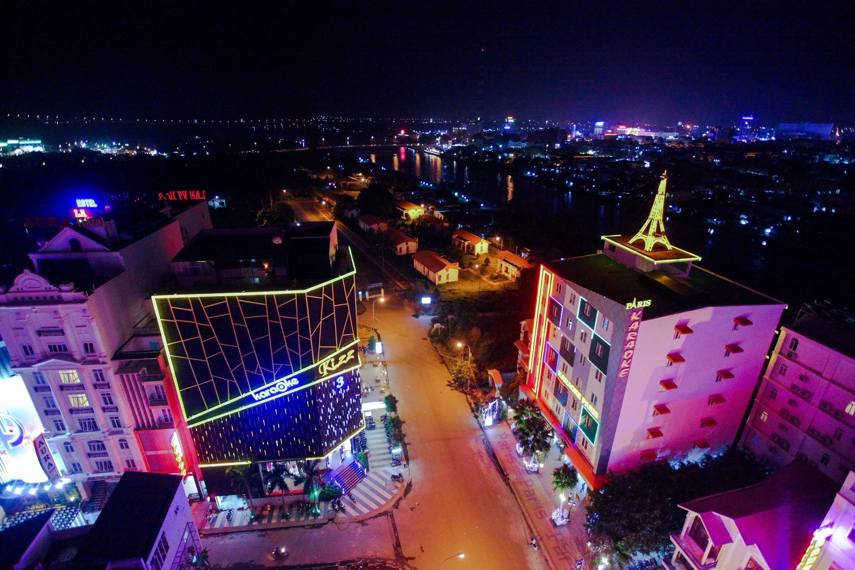 A brightly lit building with a prominent illuminated sign and a structure resembling the Eiffel Tower.