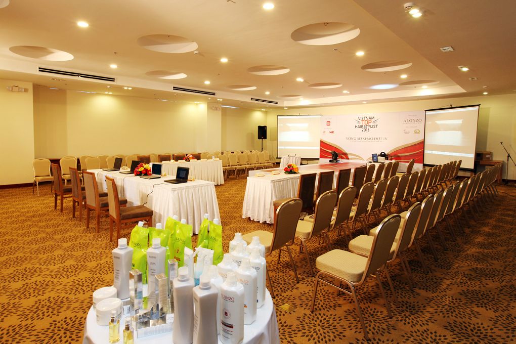 A conference room with tables, chairs, and presentation screens.