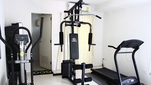 A home gym with a treadmill, elliptical, and weight machine. - The European Place (Bangkok)
