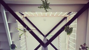 A modern interior with a central structural beam, white railings, and potted plants. - Blue Hills Motel (Battery Point)