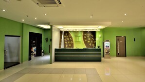 A hotel reception area with a green wall, a reception desk, and a KAGIUM sign. - Zodiak MT Haryono by KAGUM Hotels (Jakarta)