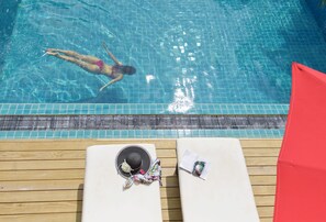 Una piscina al aire libre, tumbonas