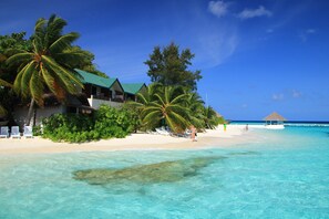 On the beach, white sand, sun loungers, beach towels