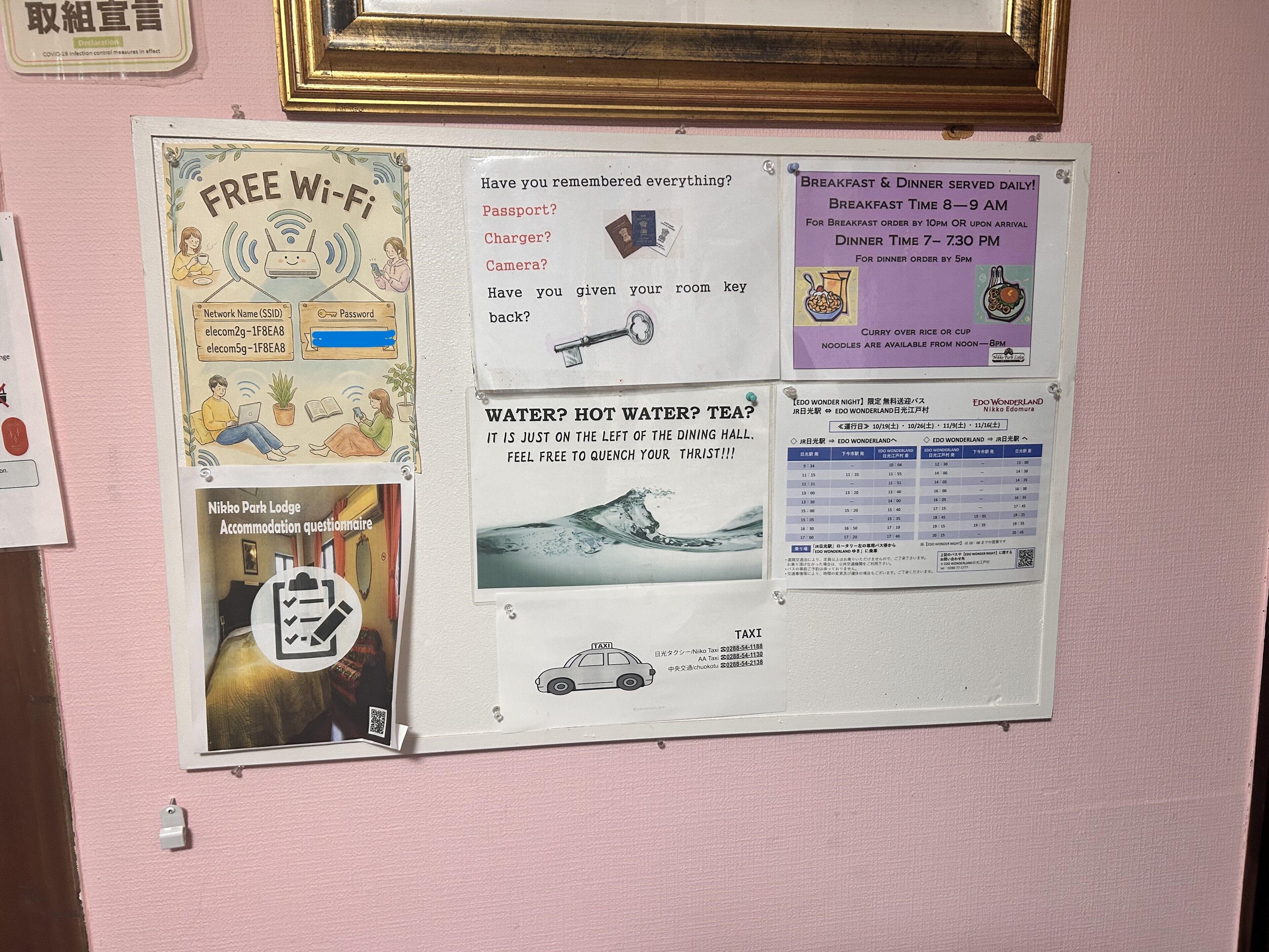 Um quadro de avisos com diversos anúncios, incluindo Wi-Fi gratuito, horários do café da manhã e jantar, e um aviso sobre água.