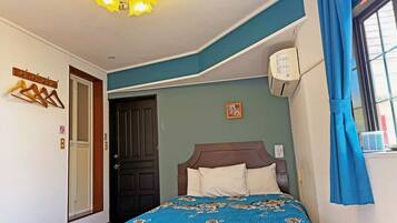 Ein Schlafzimmer mit Bett, Deckenleuchte, Tür und einem Fenster mit Vorhängen.