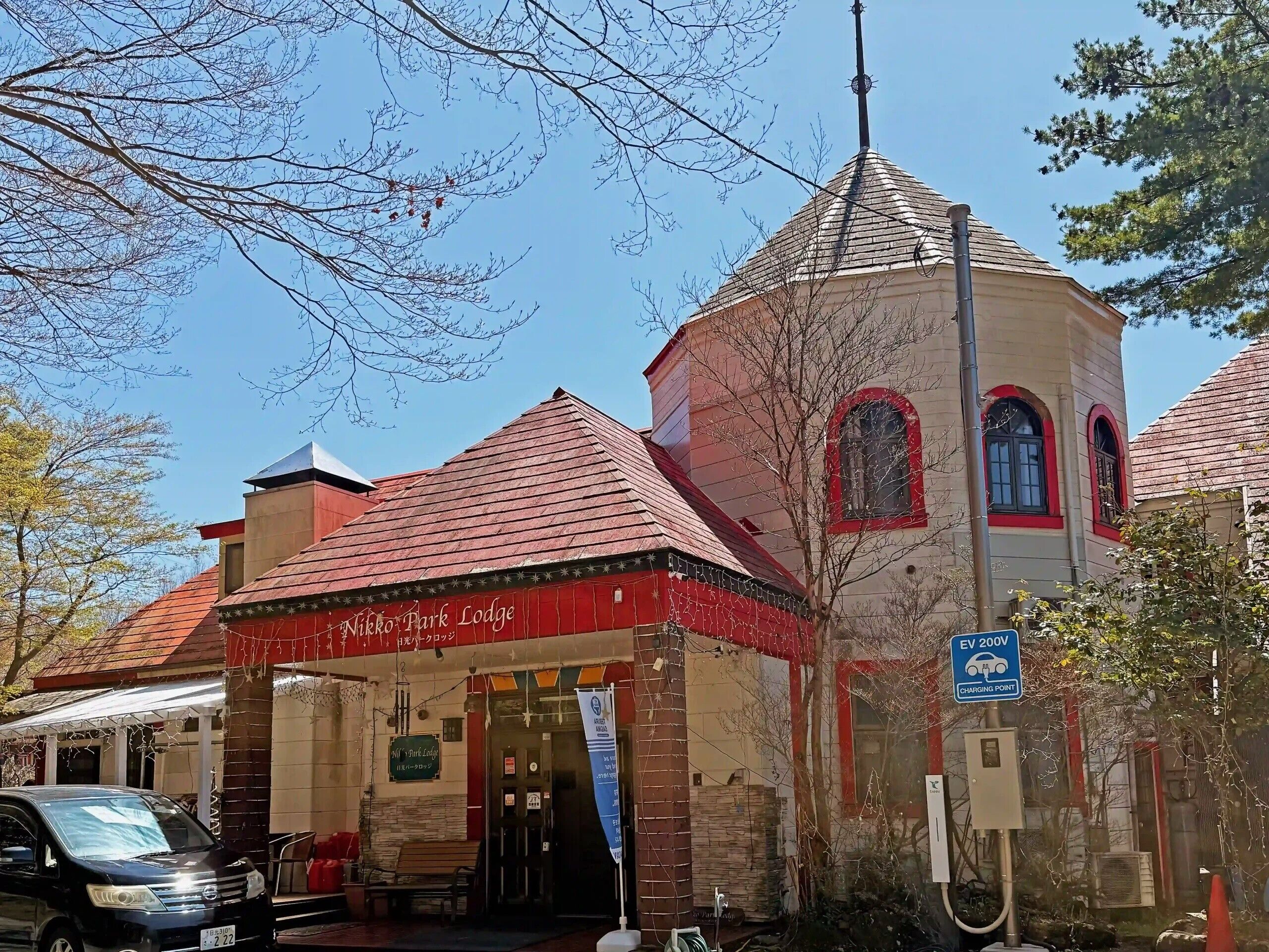 A building with a red roof, a tower, and a sign reading 'Nikko Park Lodge.'