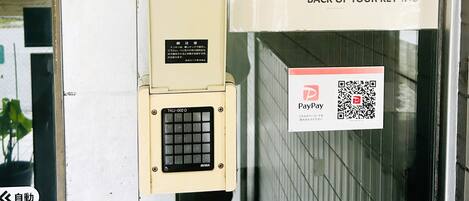 A security keypad, a surveillance camera, and multiple signs with instructions and contact numbers.